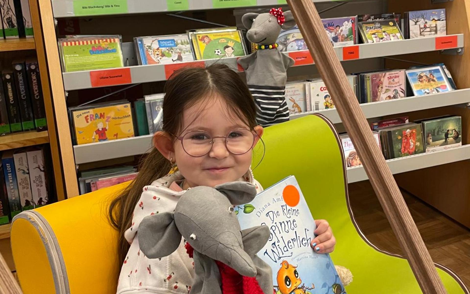 Mädchen mit Handpuppe und Buch