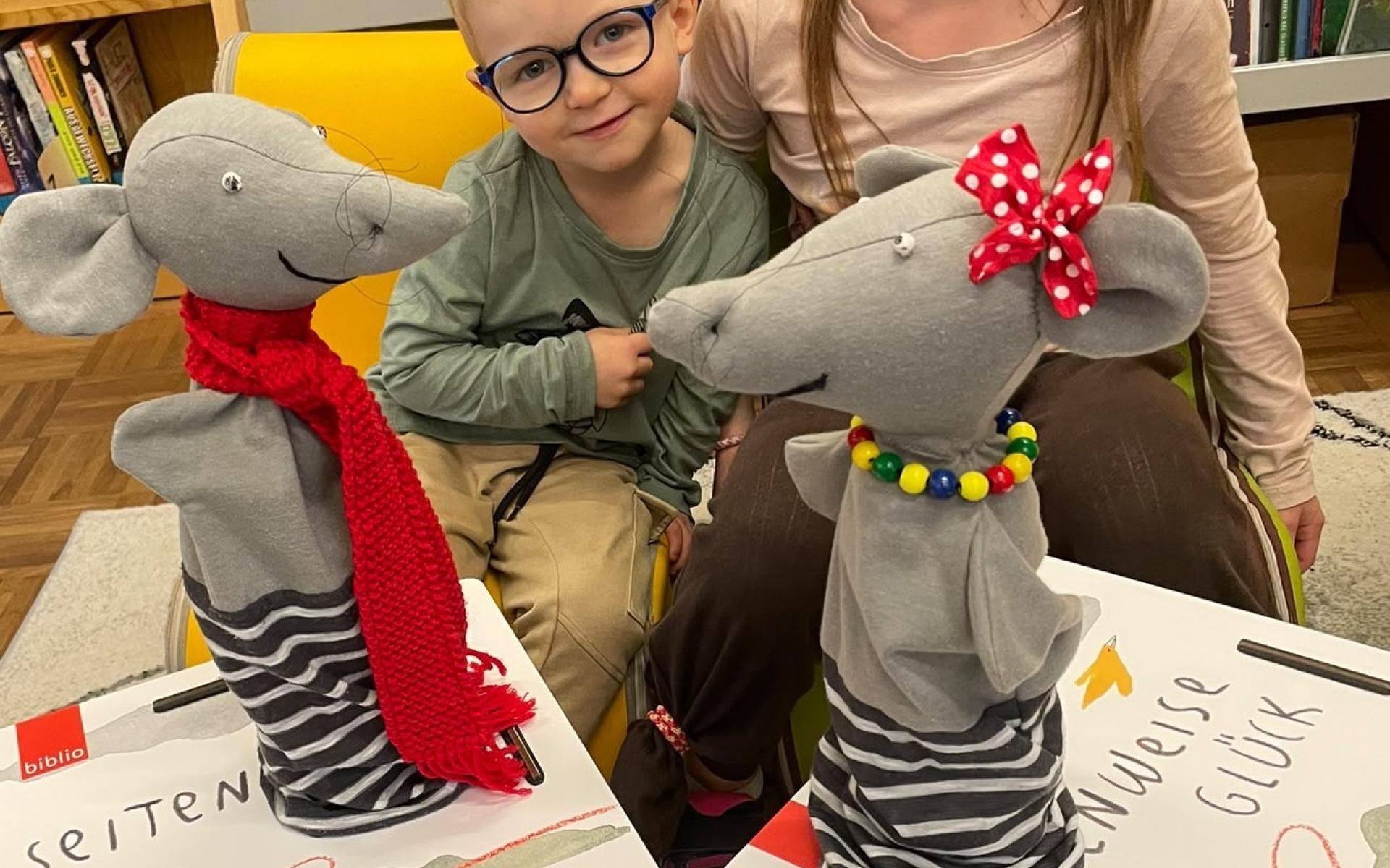 2 Kinder posieren mit Handpuppen