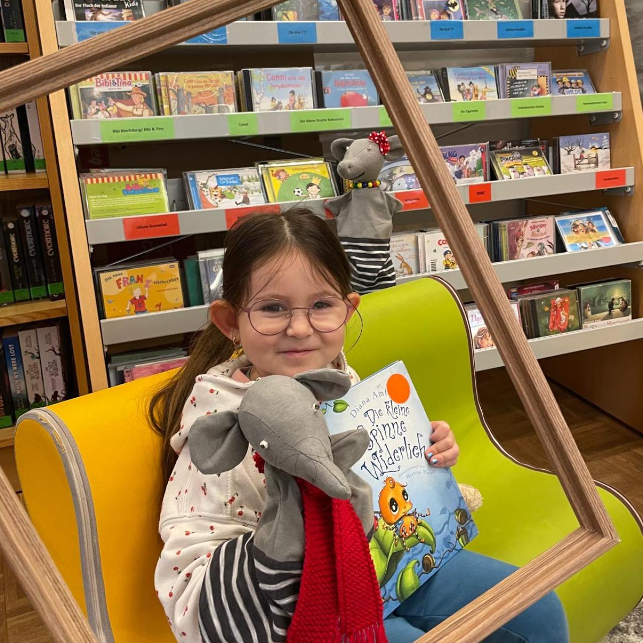 Mädchen mit Handpuppe und Buch